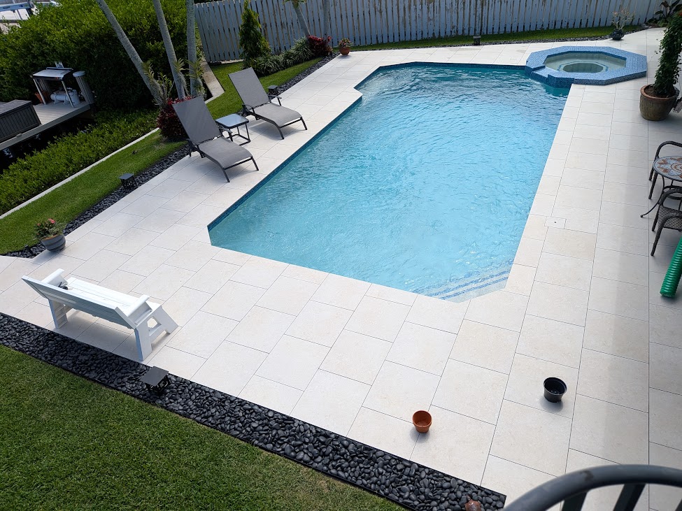 Rectangular pool with octagonal spa and travertine paver deck