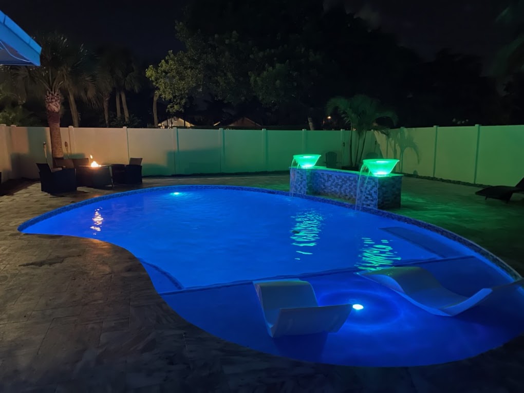 Freeform pool at night with LED lighting and lit water bowls
